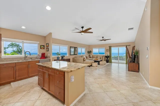 a very nice looking living room with stainless steel appliances granite countertop furniture a rug and a view of living room