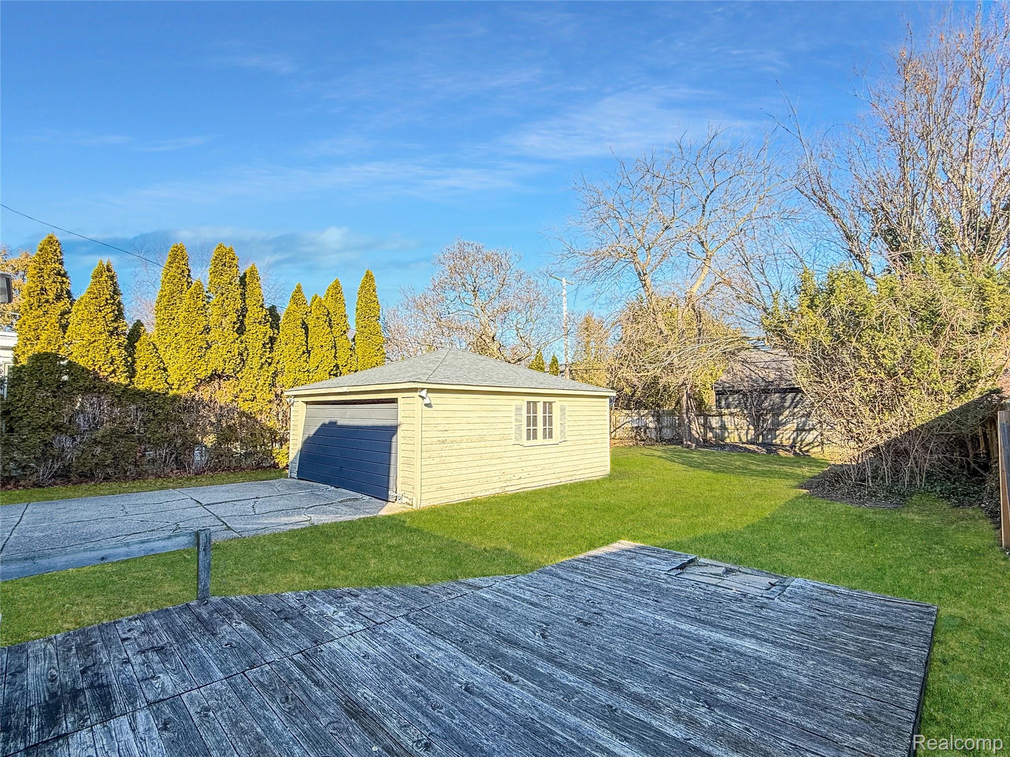 768 Washington Road Grosse Pointe, MI 48230 - Photo 32 of 54 Wooden terrace featuring an outdoor structure and a fenced backyard. This photo has been digitally enhanced.