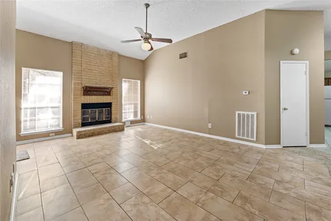 a view of empty room with fireplace and windows