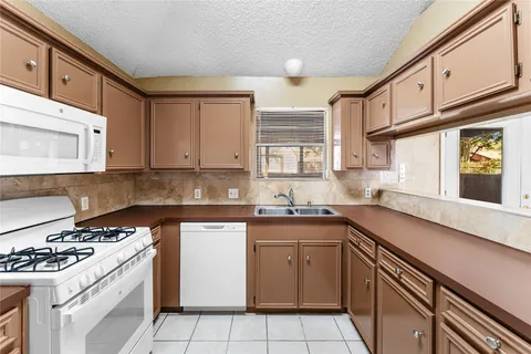 a kitchen with a sink stove top oven and cabinets