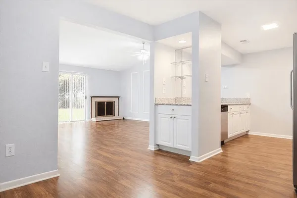a view of an empty room with wooden floor and a window