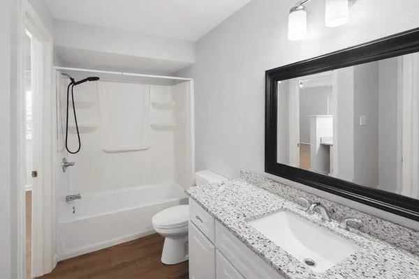 a bathroom with a granite countertop sink toilet and shower