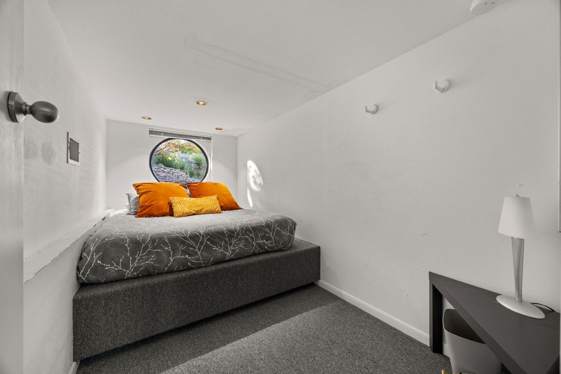 723 Coventry Road Spicewood, TX 78669 - Photo 26 of 40 a bedroom with a bed and a lamp on dresser