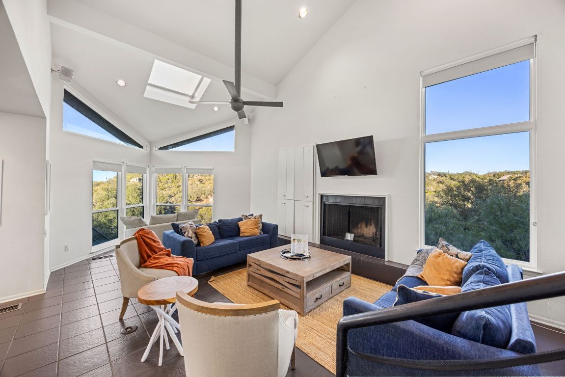 723 Coventry Road Spicewood, TX 78669 - Photo 3 of 40 a living room with furniture a fireplace and a floor to ceiling window