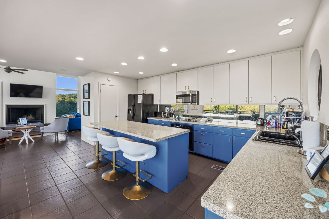 723 Coventry Road Spicewood, TX 78669 - Photo 7 of 40 a kitchen with stainless steel appliances granite countertop a refrigerator sink and stove