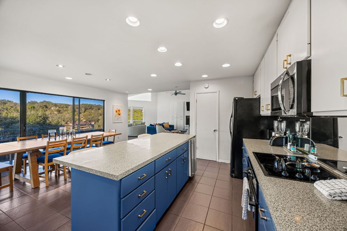 723 Coventry Road Spicewood, TX 78669 - Photo 8 of 40 a kitchen with stainless steel appliances granite countertop sink refrigerator and stove