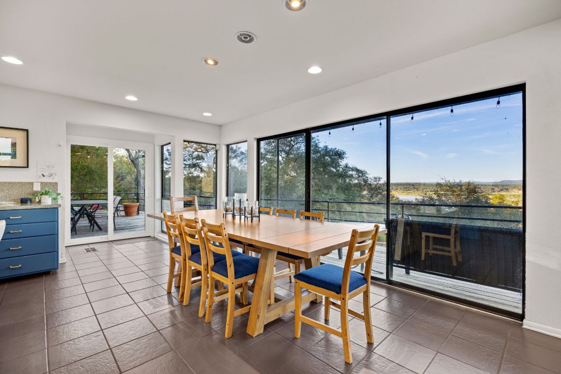 723 Coventry Road Spicewood, TX 78669 - Photo 10 of 40 a dining area with furniture a chandelier and fireplace