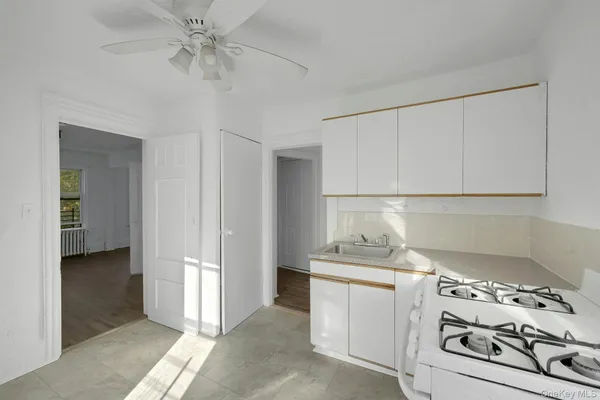 a kitchen with white cabinets and white appliances