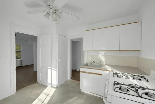 a kitchen with white cabinets and white appliances