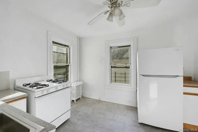 a kitchen with stainless steel appliances a refrigerator a sink a stove and white cabinets