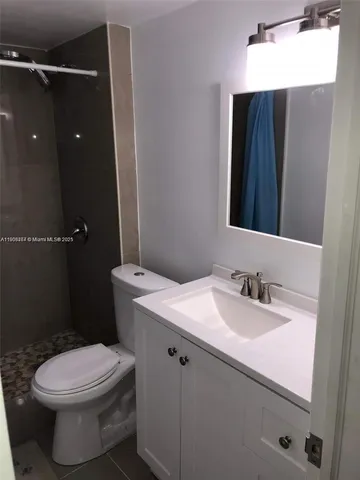 a bathroom with a sink toilet and mirror