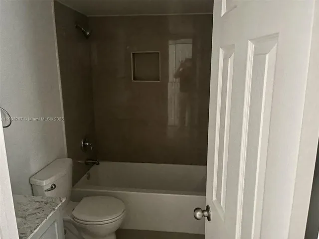 a bathroom with a toilet and a bathtub