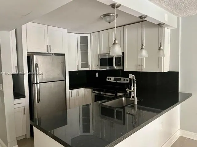 a kitchen with kitchen island a counter top space cabinets and stainless steel appliances