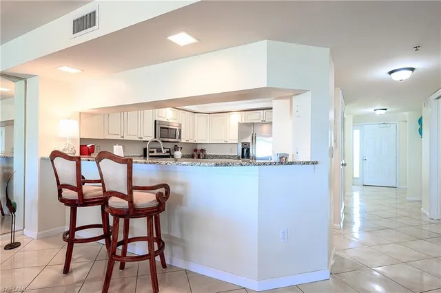 a kitchen with stainless steel appliances granite countertop a refrigerator sink and stove