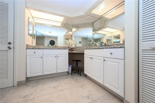 a bathroom with a granite countertop sink a mirror and shower