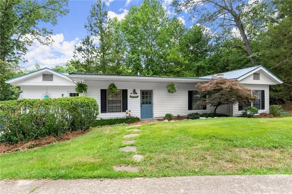 a front view of a house with a yard and trees