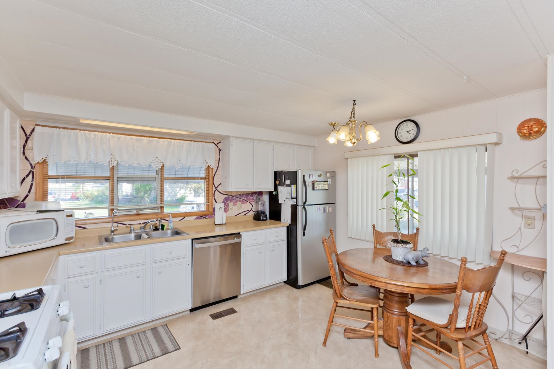 3251 E Road, Unit 20 Clifton, CO 81520 - Photo 10 of 26 a kitchen with a refrigerator a sink dishwasher a dining table and chairs