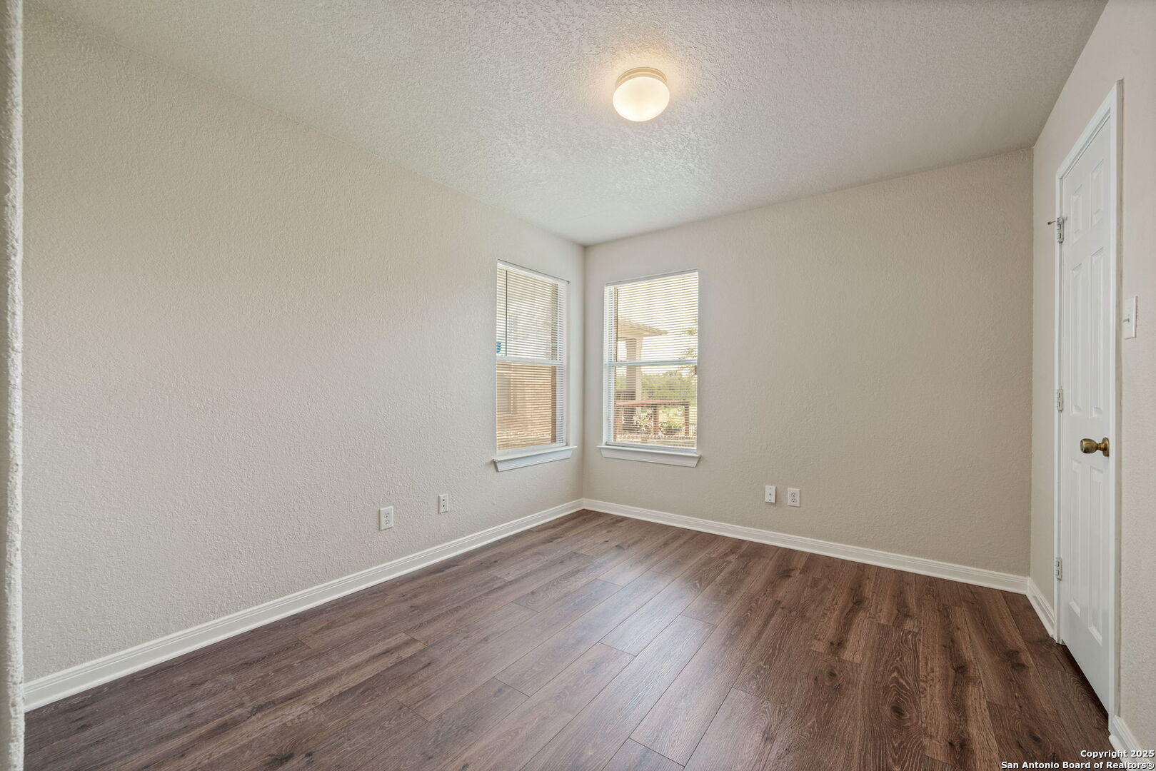 4731 Bending Grove San Antonio, TX 78259 - Photo 15 of 43 an empty room with wooden floor and windows