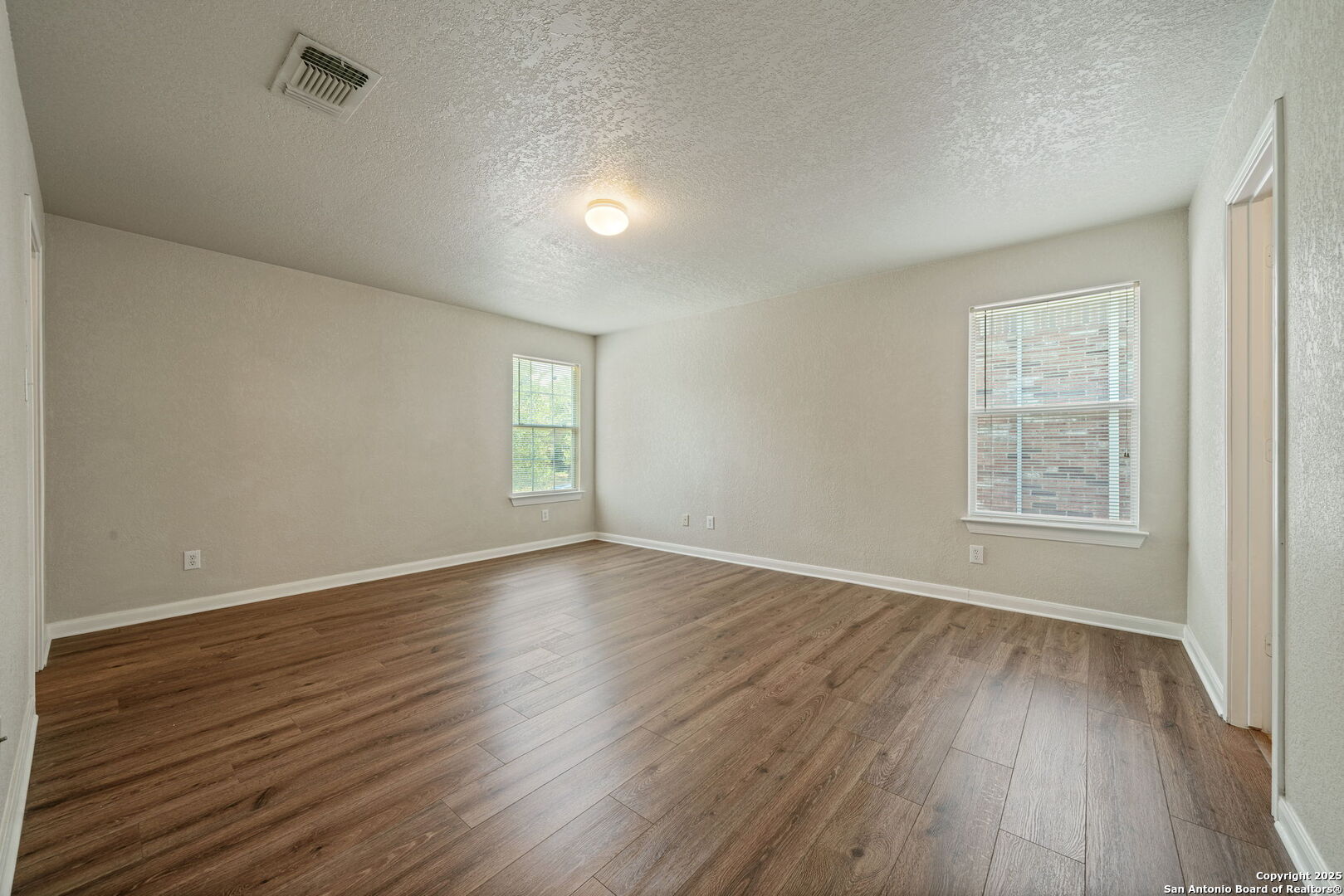4731 Bending Grove San Antonio, TX 78259 - Photo 17 of 43 an empty room with wooden floor and windows