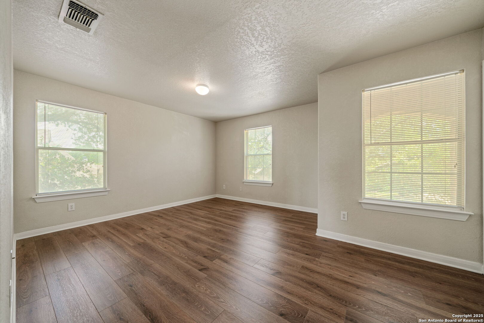 4731 Bending Grove San Antonio, TX 78259 - Photo 21 of 43 an empty room with wooden floor and windows