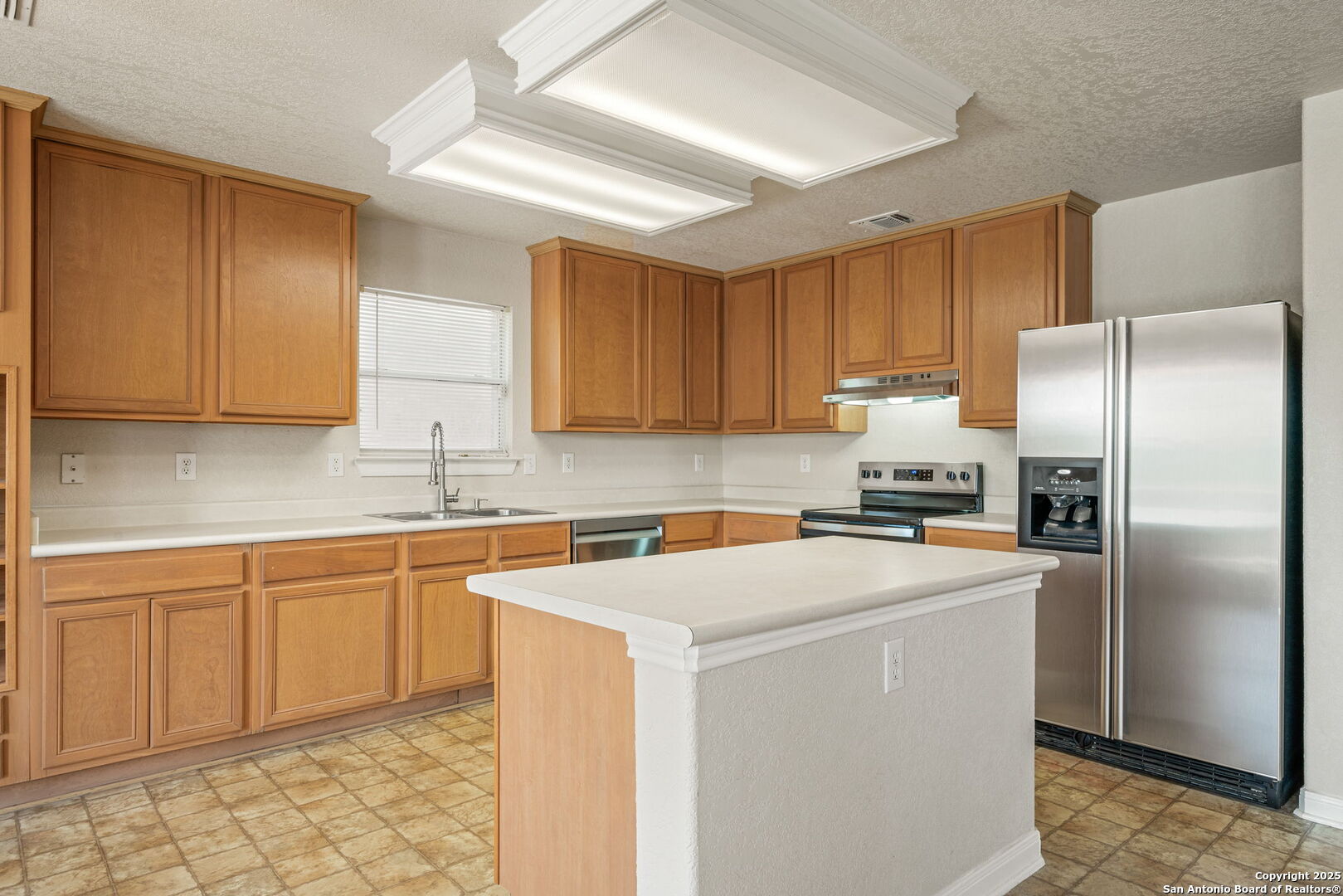 4731 Bending Grove San Antonio, TX 78259 - Photo 25 of 43 a kitchen with a sink a refrigerator and cabinets