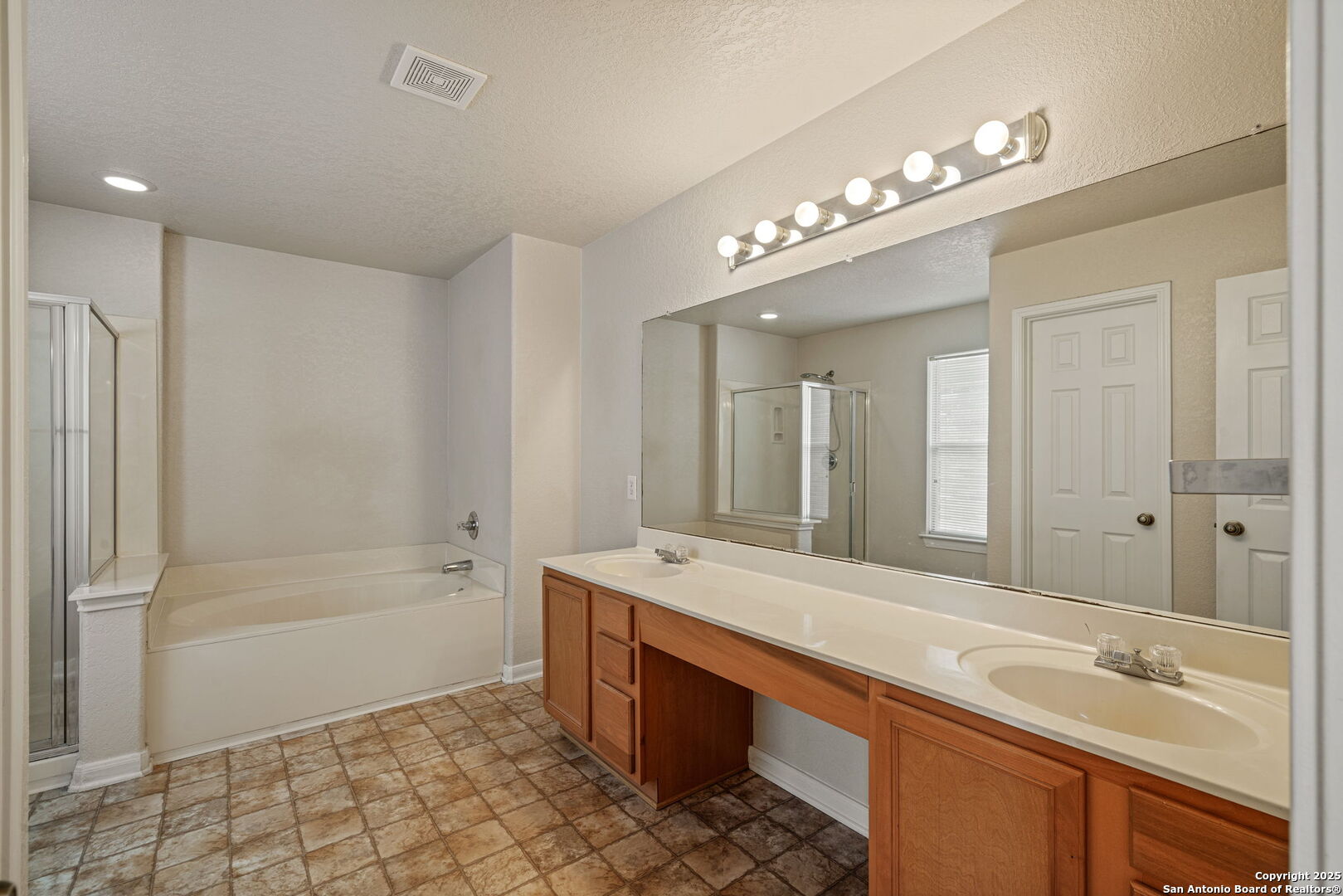 4731 Bending Grove San Antonio, TX 78259 - Photo 29 of 43 a spacious bathroom with a sink a large mirror and a bathtub