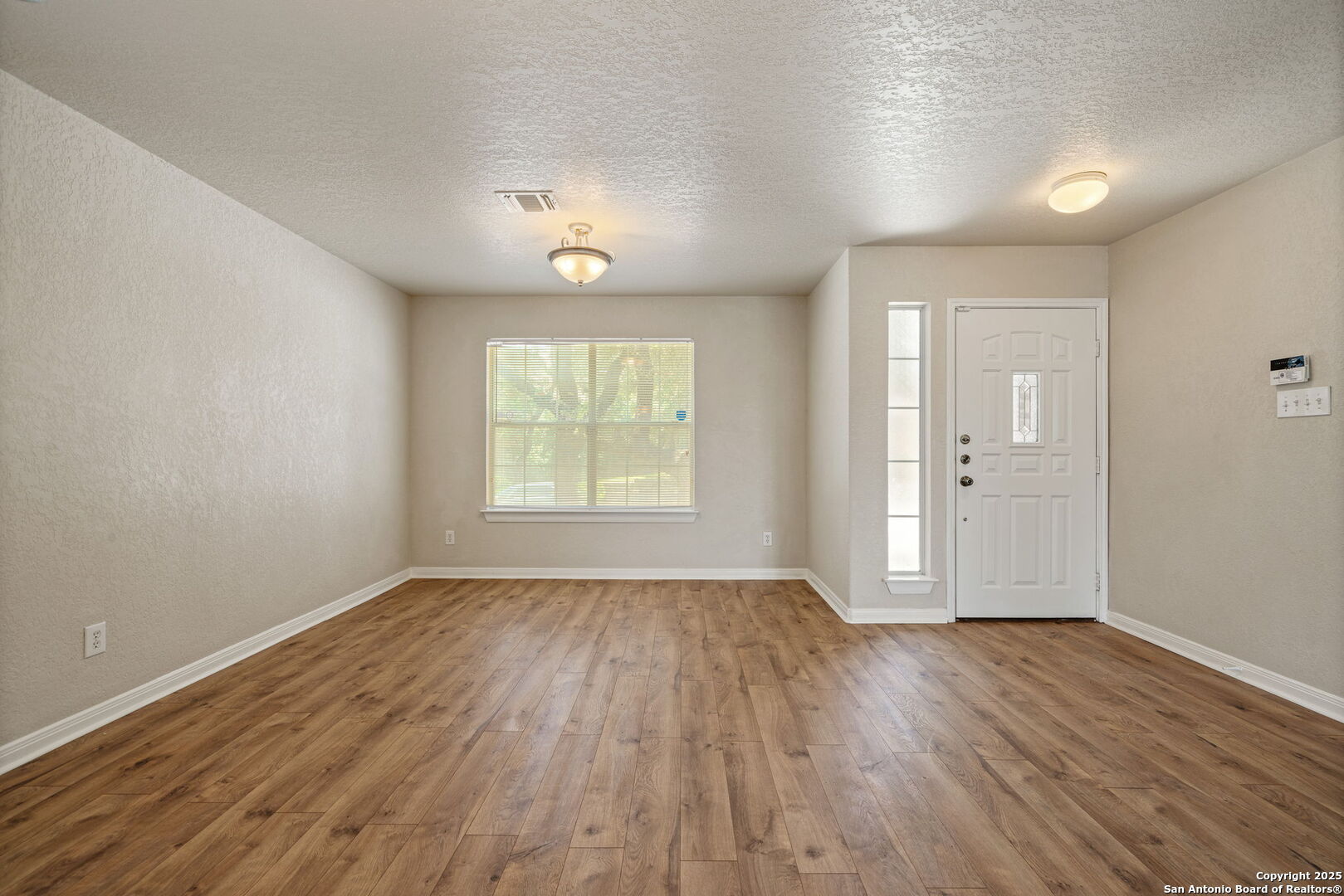 4731 Bending Grove San Antonio, TX 78259 - Photo 3 of 43 an empty room with wooden floor and windows