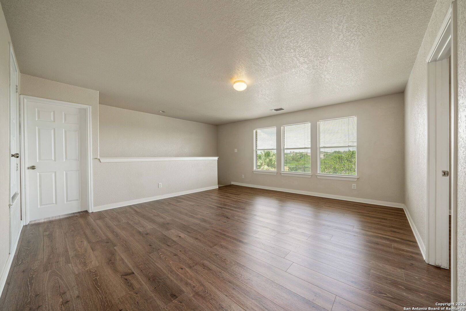 4731 Bending Grove San Antonio, TX 78259 - Photo 33 of 43 an empty room with wooden floor and windows