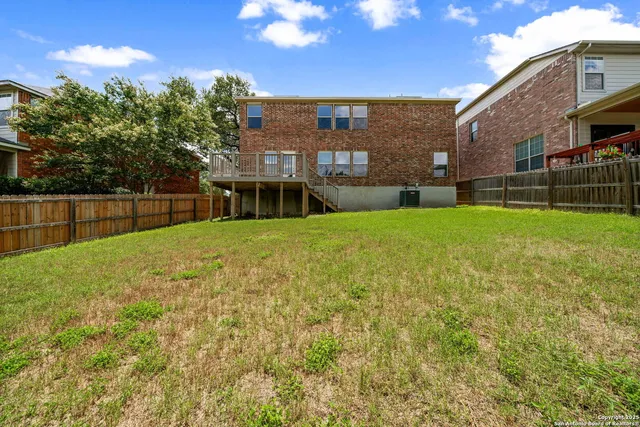 a view of a house with backyard and a tree