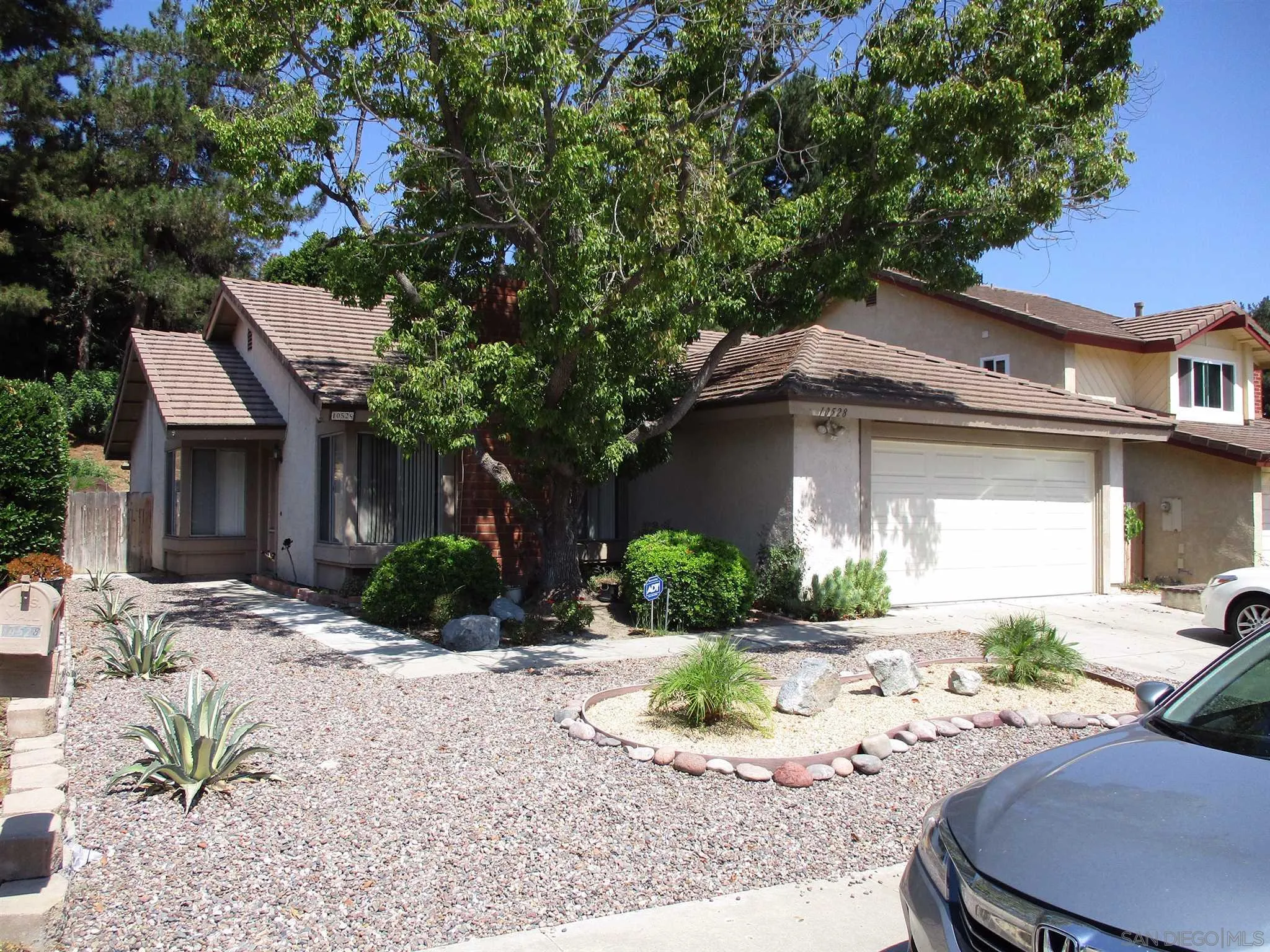 a front view of a house with a yard and potted plants