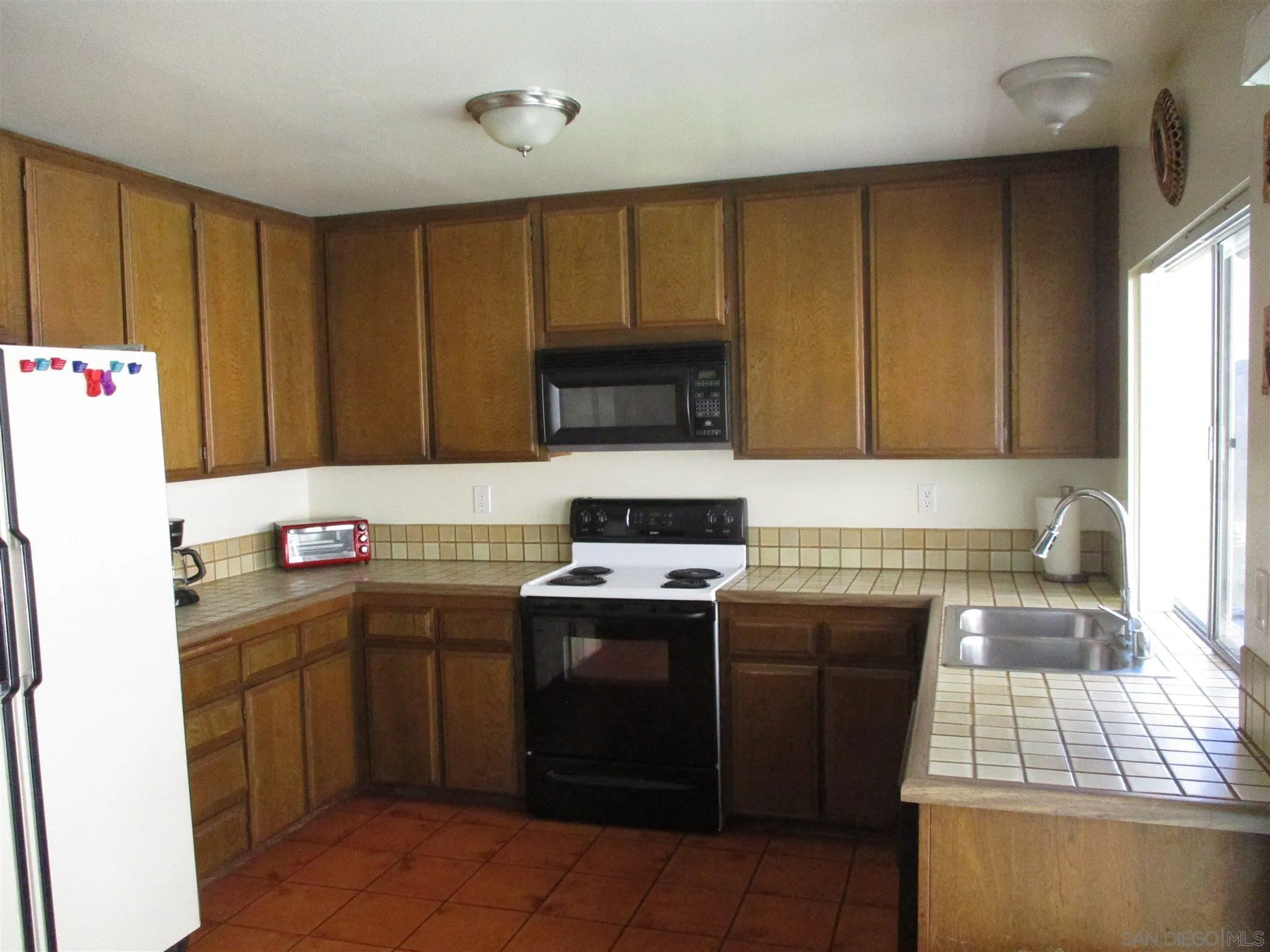10528 Moorpark Street Spring Valley, CA 91978 - Photo 3 of 3 a kitchen with a sink stove and cabinets