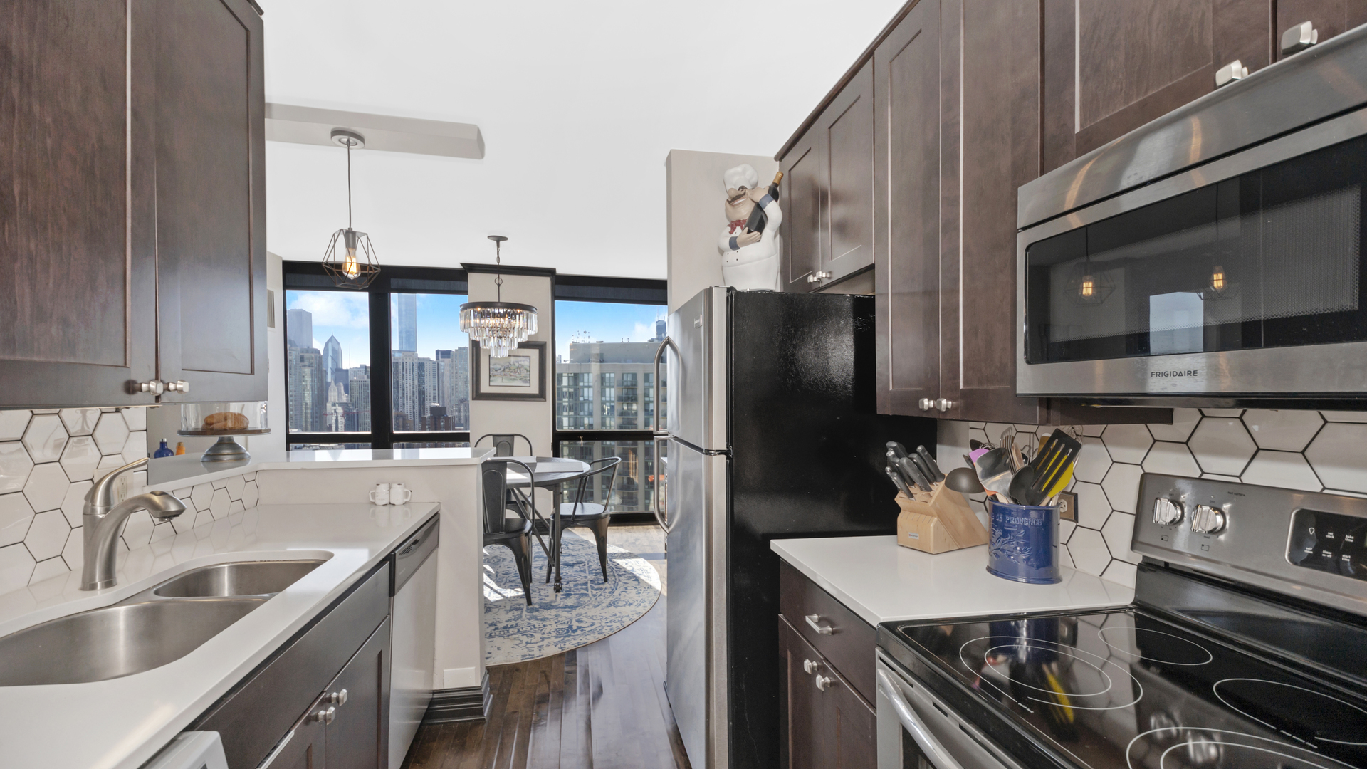 1122 North Clark Street, Unit 3808 Chicago, IL 60610 - Photo 13 of 29 a kitchen with stainless steel appliances a sink stove and refrigerator