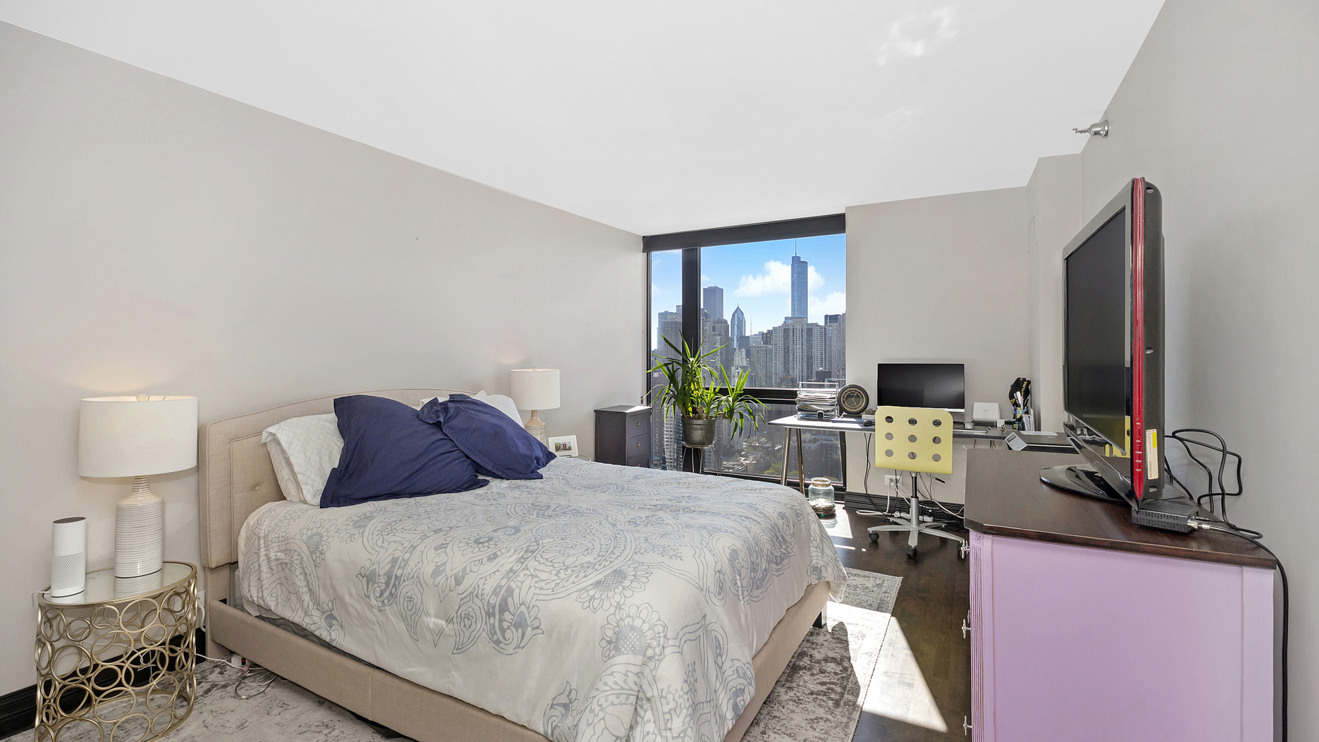 1122 North Clark Street, Unit 3808 Chicago, IL 60610 - Photo 17 of 29 a bedroom with a bed a large window and a flat screen tv