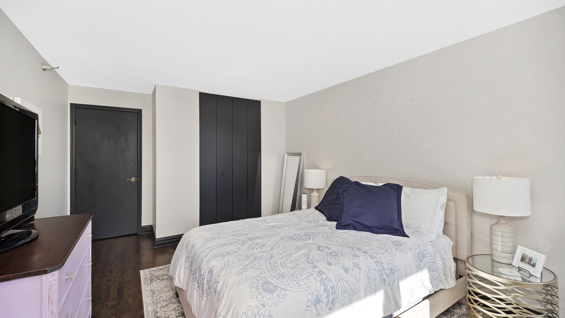 1122 North Clark Street, Unit 3808 Chicago, IL 60610 - Photo 18 of 29 a bedroom with a bed and a flat tv screen on a dresser
