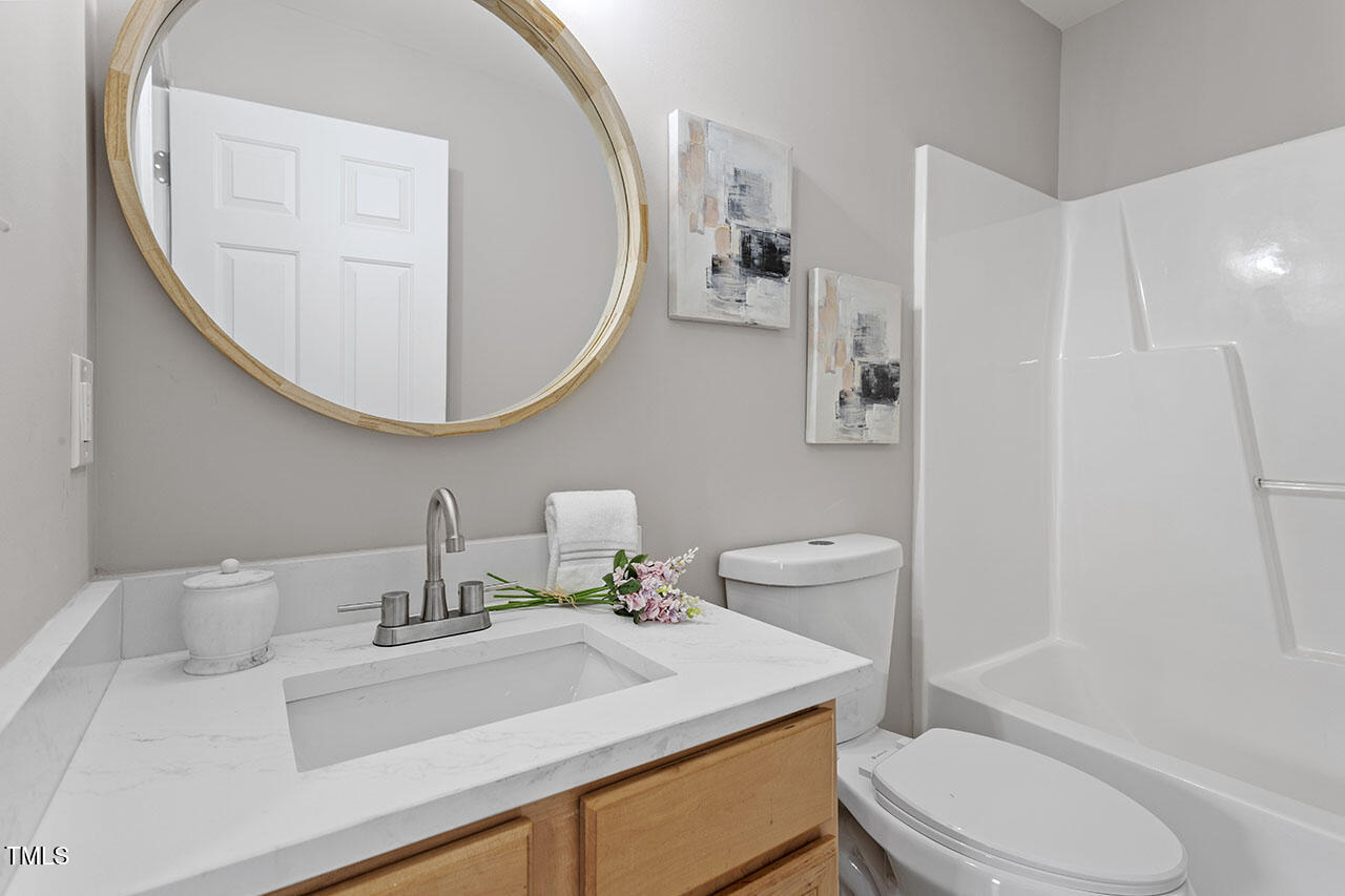 5340 Big Bass Drive Raleigh, NC 27610 - Photo 16 of 20 a bathroom with a sink a toilet and a mirror