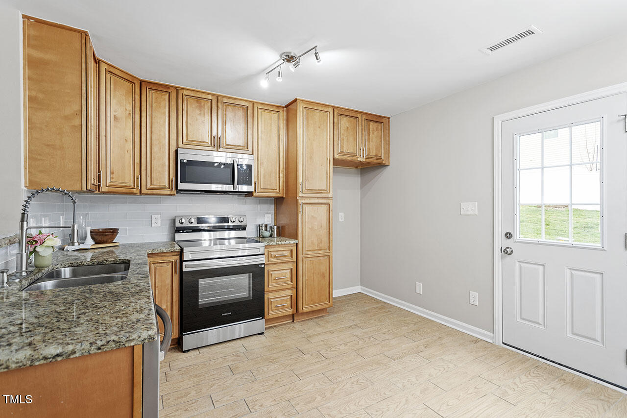 5340 Big Bass Drive Raleigh, NC 27610 - Photo 8 of 20 a kitchen with stainless steel appliances granite countertop a stove a sink and a refrigerator