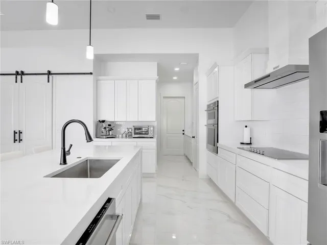a large white kitchen with a large window