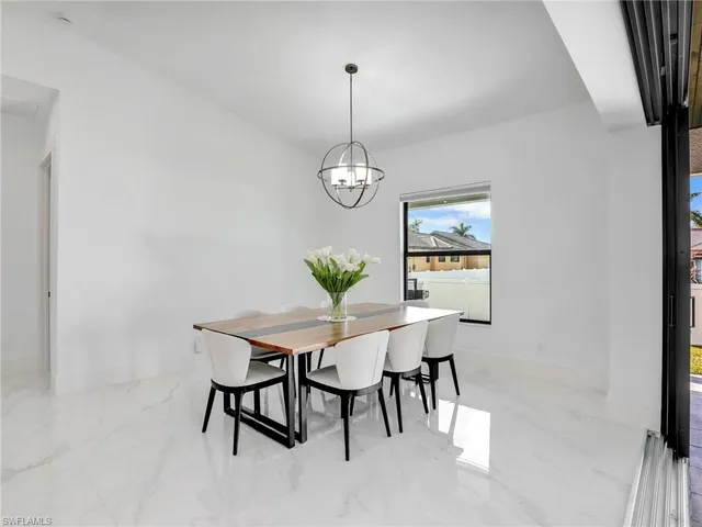 a large white kitchen with a sink a refrigerator and cabinets