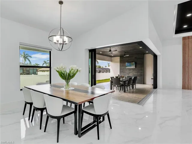 a dining room with furniture a rug and a chandelier