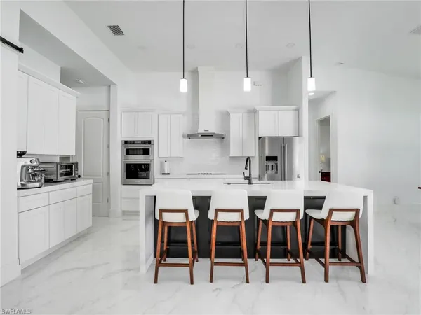 a kitchen with appliances a sink a counter space and a center island