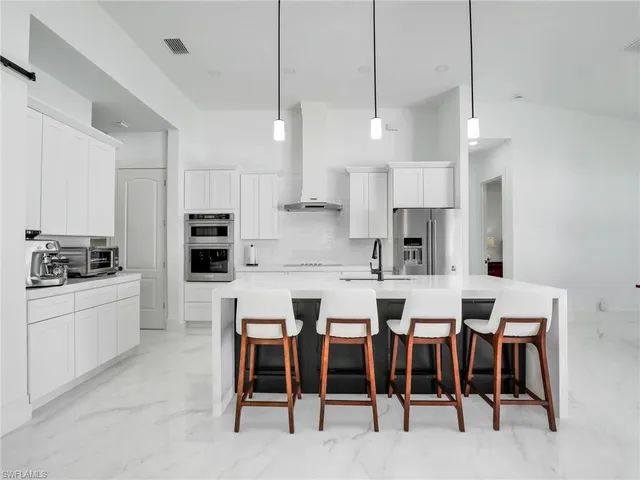 a kitchen with appliances a sink a counter space and a center island