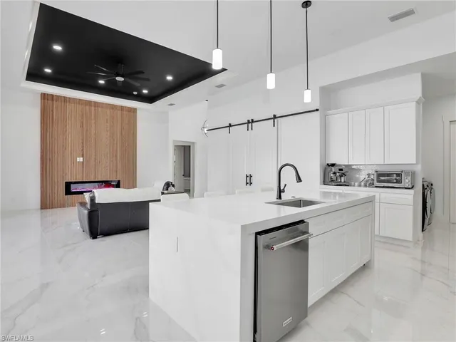 a large kitchen with stainless steel appliances kitchen island a white counter space a sink and cabinets