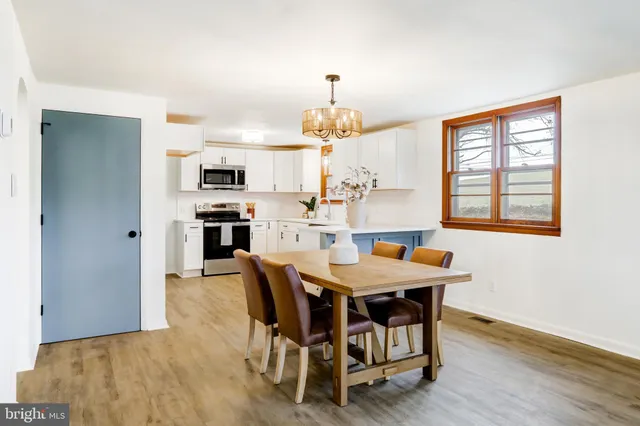 a kitchen with a sink white cabinets and stainless steel appliances