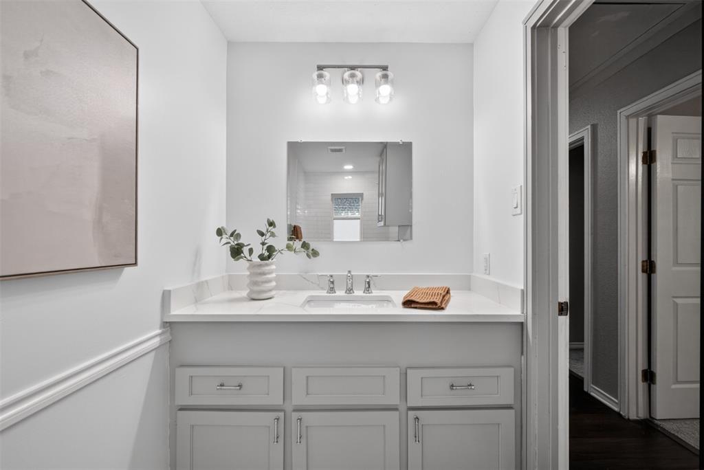 9660 Timberleaf Drive Dallas, TX 75243 - Photo 27 of 40 Bathroom vanity featuring a single basin sink, chrome faucet, and white countertop