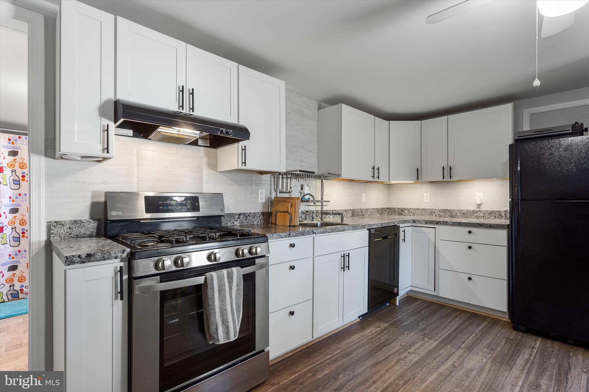 337 Old Charles Town Road Stephenson, VA 22656 - Photo 13 of 27 a kitchen with cabinets stainless steel appliances and wooden floor