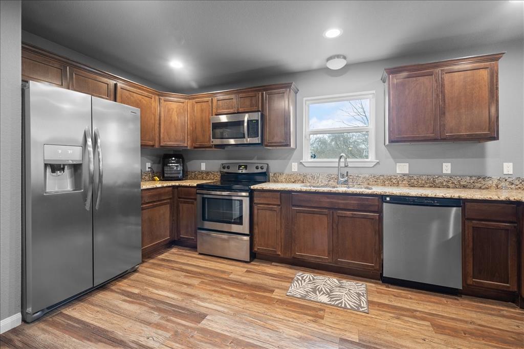 512 Alameda Road Azle, TX 76020 - Photo 12 of 28 a kitchen with granite countertop a refrigerator stove top oven and sink