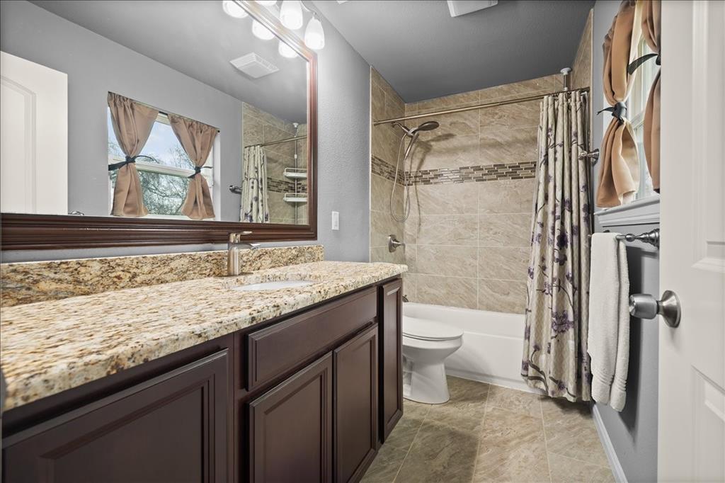 512 Alameda Road Azle, TX 76020 - Photo 16 of 28 a bathroom with a granite countertop sink toilet and shower