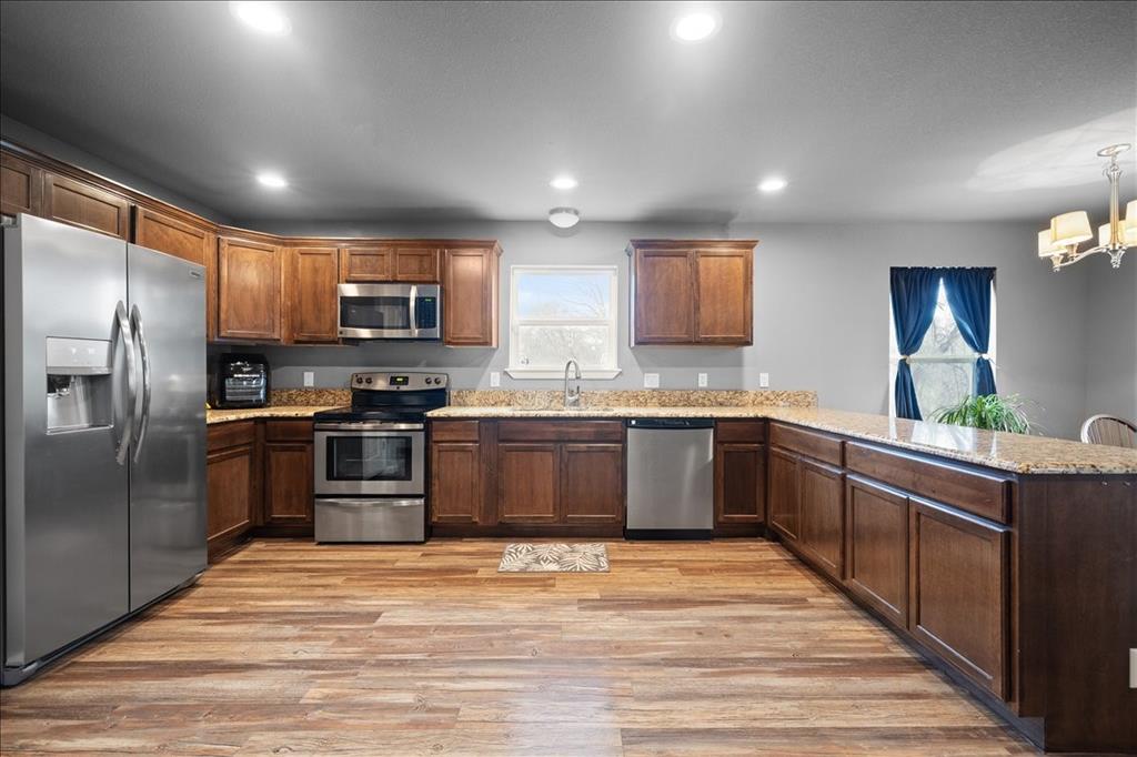512 Alameda Road Azle, TX 76020 - Photo 8 of 28 a large kitchen with stainless steel appliances kitchen island granite countertop a refrigerator and a stove top oven