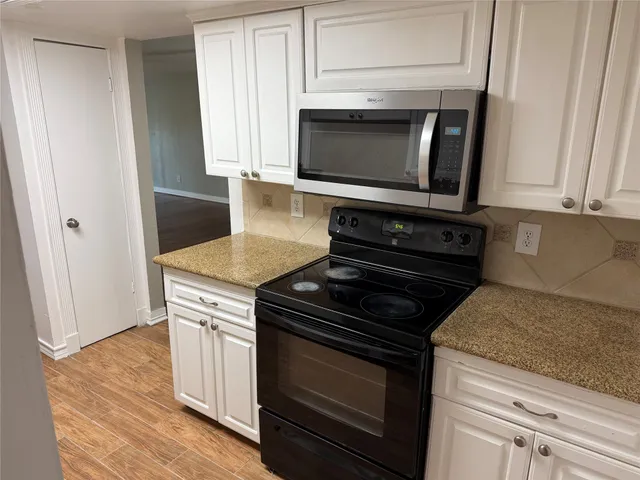 a kitchen with granite countertop a stove and a microwave