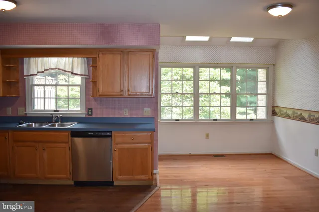 a kitchen with a sink a window and cabinets